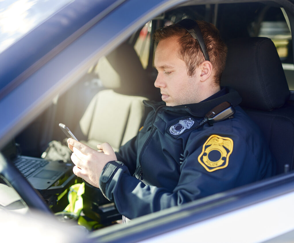 Law Enforcement in car looking at device